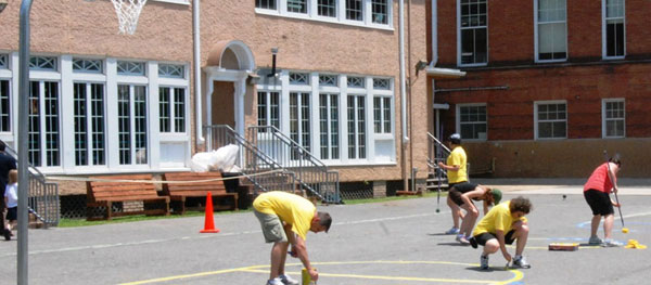 Volunteers from Davis Vision and HandsOn New Orleans help create a basketball court on the Esperanza School playground. 