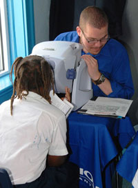 A volunteer tests an Esperanza student&rsquo;s eyes at the Davis Vision free clinic. 