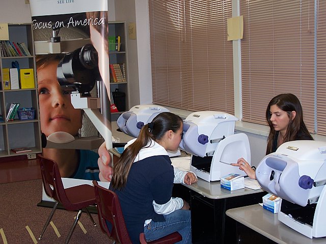 Un estudiante de la Escuela Primaria Larragoite en Santa Fe recibe ayuda de Amy Stack (Davis Vision) para su examen, durante los recientes ex&aacute;menes de visi&oacute;n Focus on America de la compa&ntilde;&iacute;a.